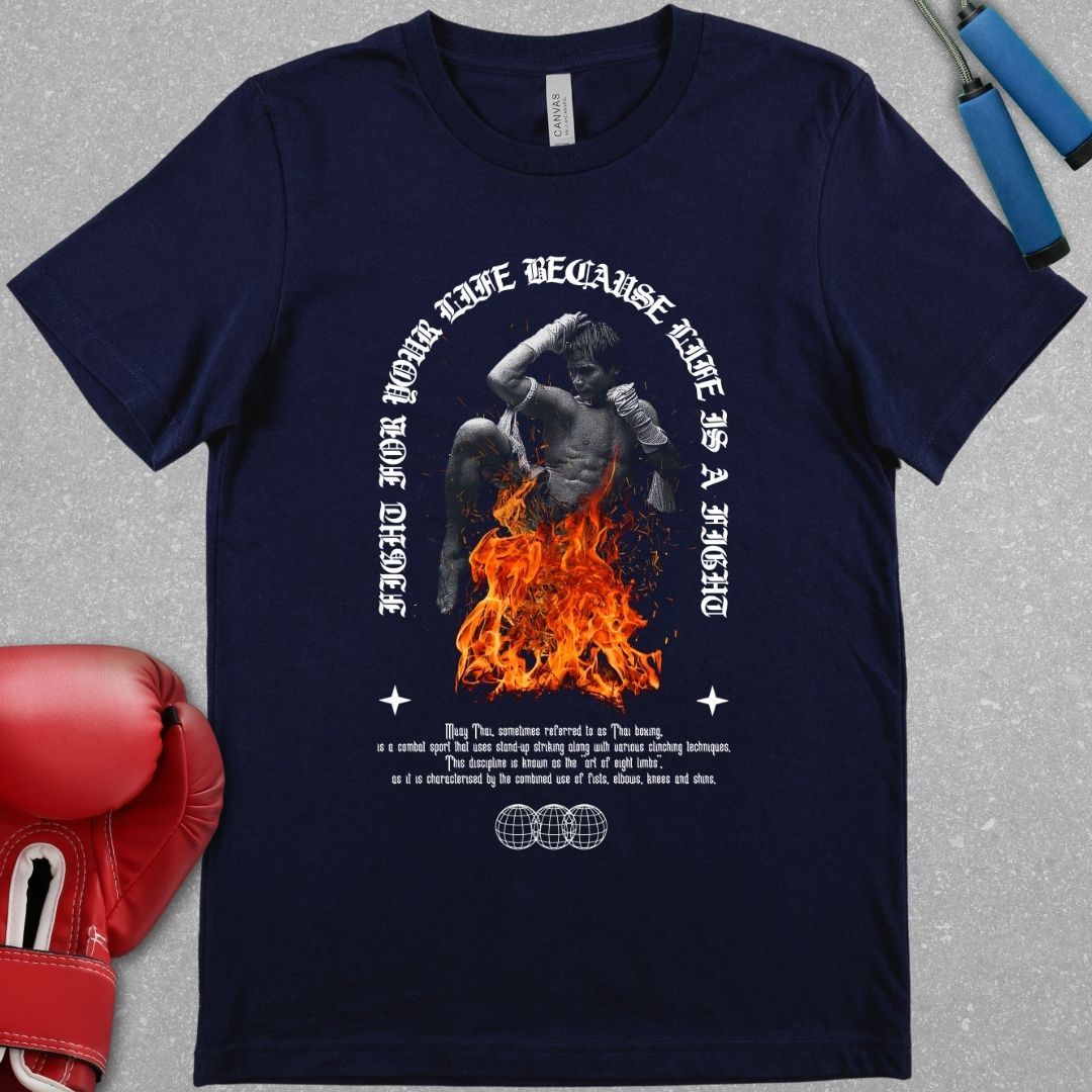 Navy shirt with a design that has a picture of a Muay Boran fighter with fire around him and the phrase Fight for your life cause life is a fight is on the shirt. Also a short description of the definition of Thai boxing is on the shirt.
