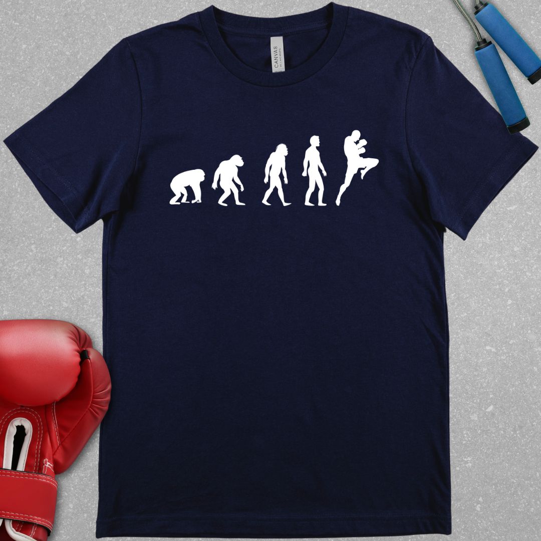 Navy shirt with a graphic design showing the evolution of humans from apes and then the final evolution is a muay thai fighter throwing a knee