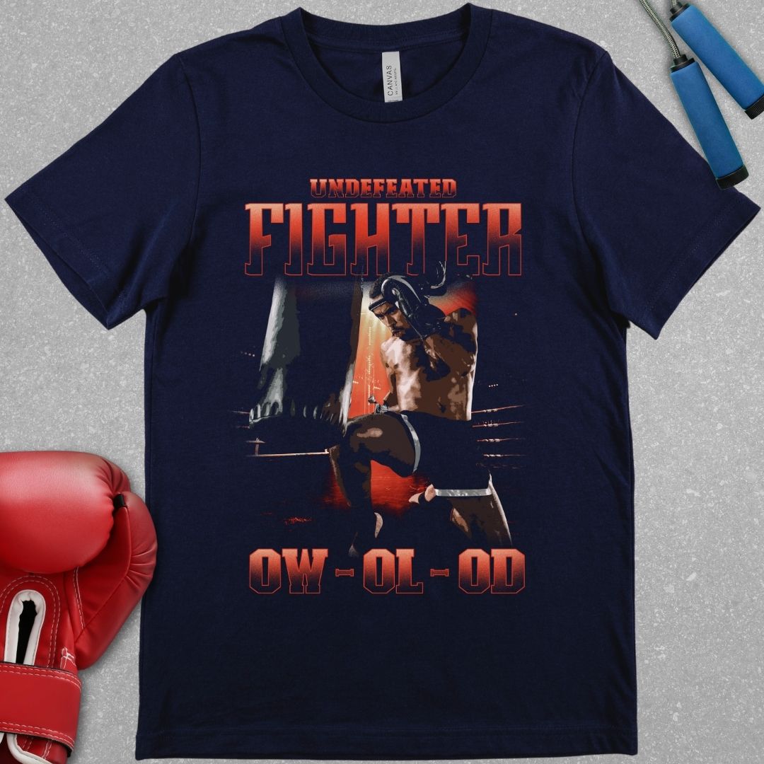 Navy shirt with a design that has the words undefeated fighter at the top of the design and 0W 0L 0D at the bottom of the designs. The design has a fighter throwing a flying knee at the Muay Thai bag.