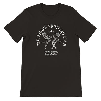 Black shirt with the slogan The Shark Fighting Club . It has a picture of a muay thai fighter throwing a knee at the shark with the phrase In the depths, legends will rise.