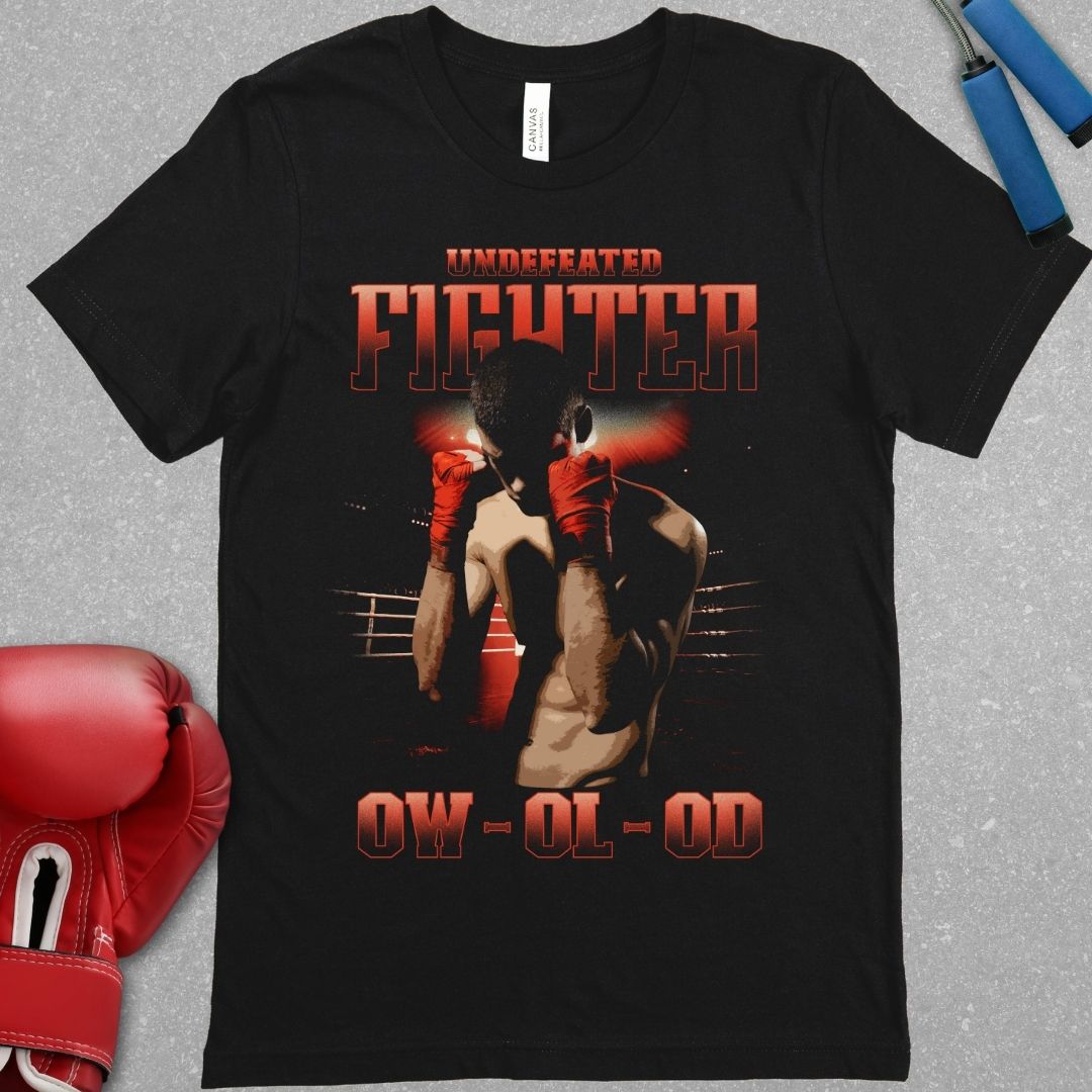 Black shirt with a design that has the words undefeated fighter at the top of the design and 0W 0L 0D at the bottom of the designs. The design has a fighter with his hands up in the ring.