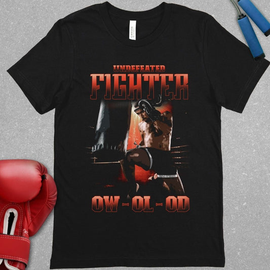 Black shirt with a design that has the words undefeated fighter at the top of the design and 0W 0L 0D at the bottom of the designs. The design has a fighter throwing a flying knee at the Muay Thai bag.