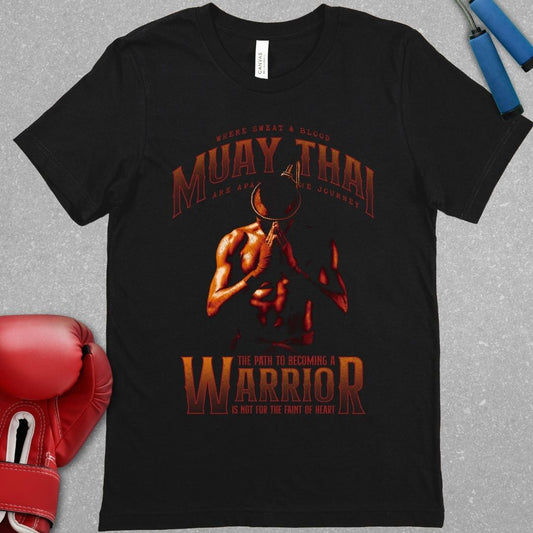 Black shirt with a red design. The design features a Muay Thai fighter wearing the Mongkhon and bowing his head with his hands in prayer. The top of the shirt features the words Muay Thai and the phrase - Where sweat and blood are a part of the journey. The bottom of the shirt features the phrase - the path to becoming a warrior is not for the faint of heart.